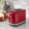 Piros színű kenyérpirító teljes egészében fém felépítéssel.